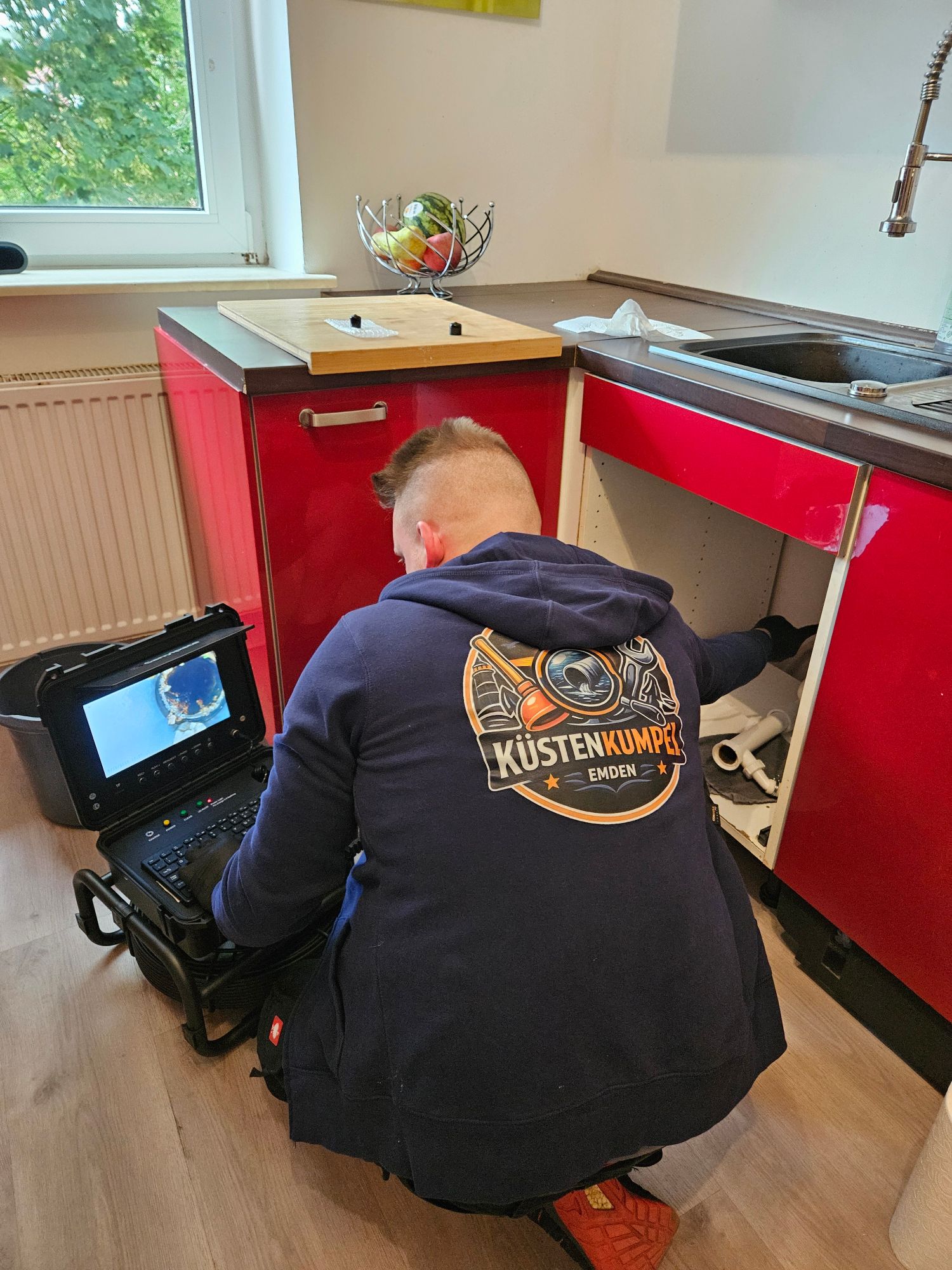 Küstenkumpel bei der Rohrkamerainspektion unter der Küchenspüle